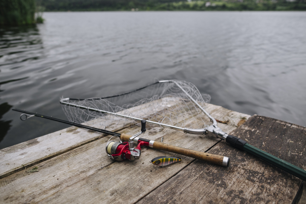 fishing-rod-with-lure-net-wooden-pier-idyllic-lake.jpg
